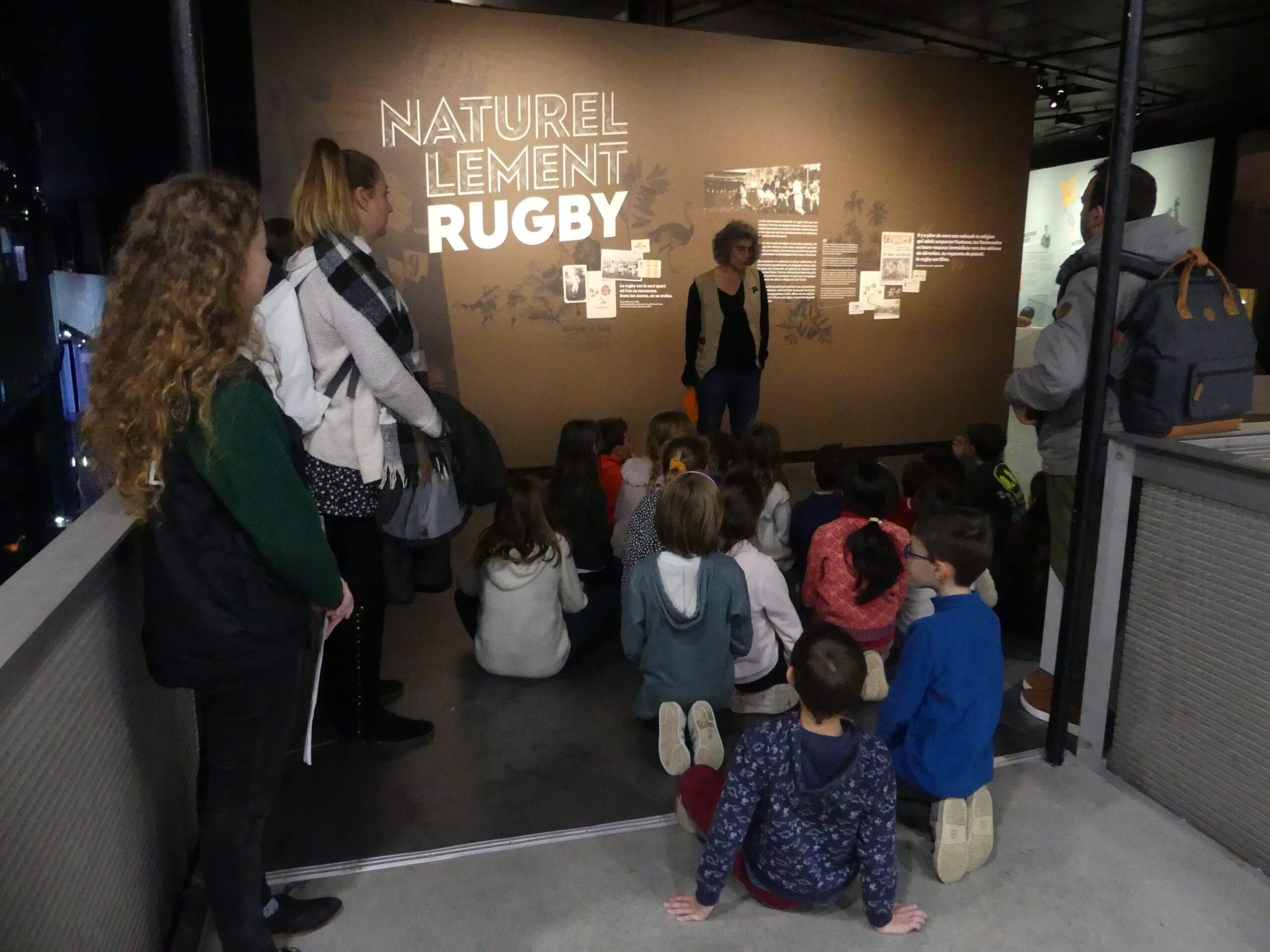 Photographie d’un groupe d’enfant devant l’exposition temporaire « naturellement rugby » au muséum